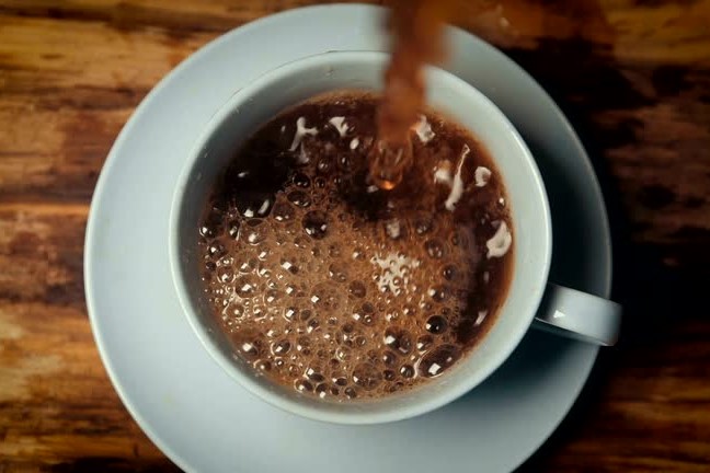 Slow motion coffee pouring in cup