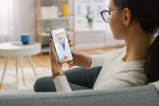 Young Girl Sick at Home Using Smartphone to Talk to Her Doctor via Video Conference Medical App. Woman Checks Possible Symptoms with Professional Physician, Using Online Video Chat Application